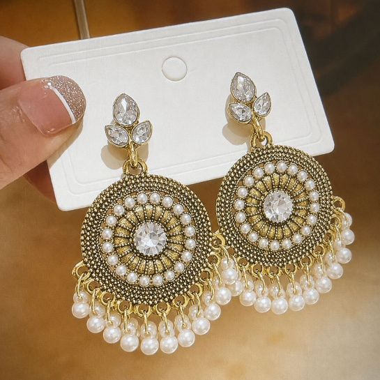 “Elegant gold earrings with sparkling crystal stones and turquoise bead detailing for a royal look.”